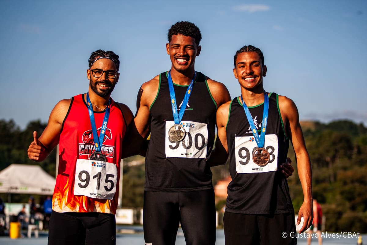Atletas da Atletismo-UEM no pódio com medalhas ao lado de atleta de outra equipe