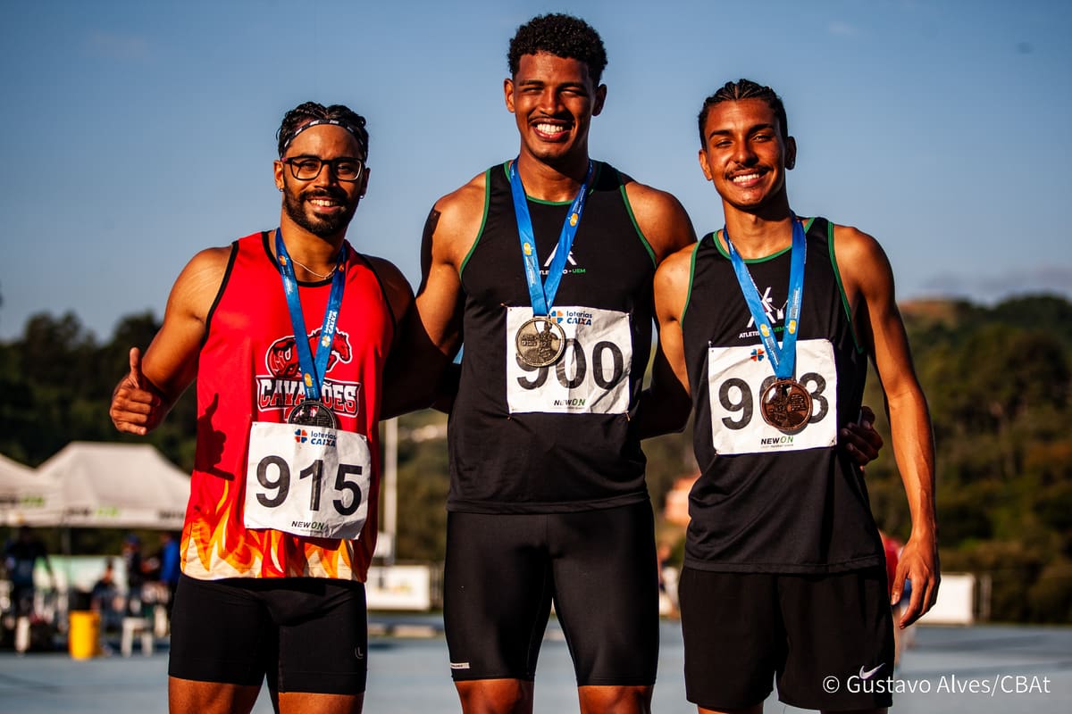Atletas da Atletismo-UEM no pódio com medalhas ao lado de atleta de outra equipe