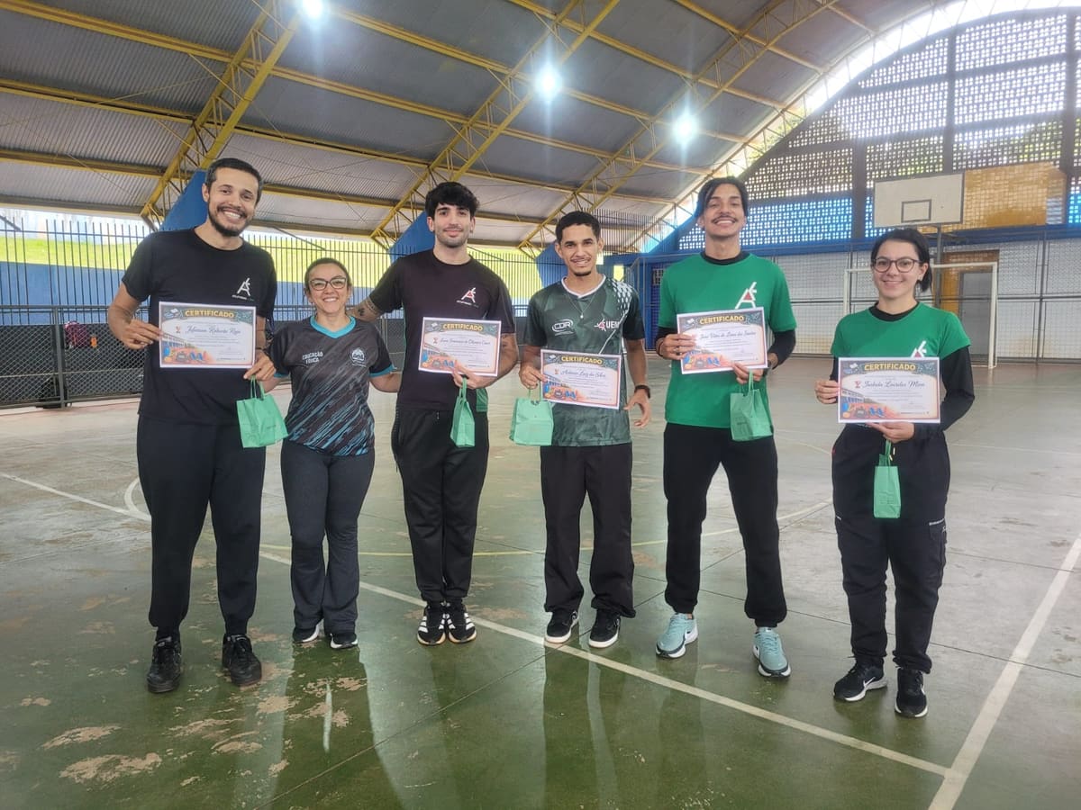 Professor Jeferson Rojo, tutores do Atletismo-UEM e professora da rede municipal de Mandaguaçu posam com certificados de participação na formação